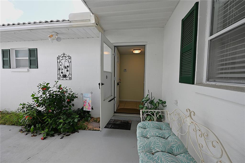 A hallway with light-colored walls and tiled flooring leads toward an open doorway — 3535 AMITY AVENUE UNIT 3535, LAKELAND, FL