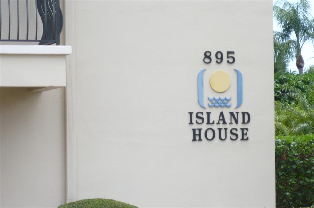 The exterior wall of a building features the address number 895 and an Island House sign — 895 S GULFVIEW BOULEVARD UNIT 303, CLEARWATER BEACH, FL