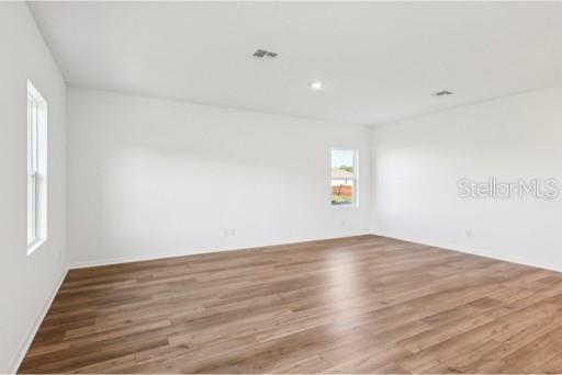An empty room with white walls, light wood-look flooring, and two windows — 3173 SAILHOUSE DRIVE, ST CLOUD, FL