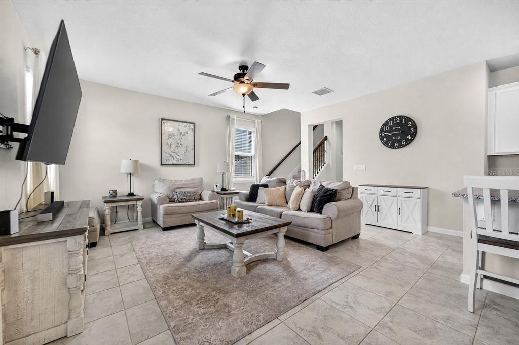 A living room features a sofa, armchair, coffee table, television, and tile flooring — 11618 GOLD DUST COURT, RIVERVIEW, FL