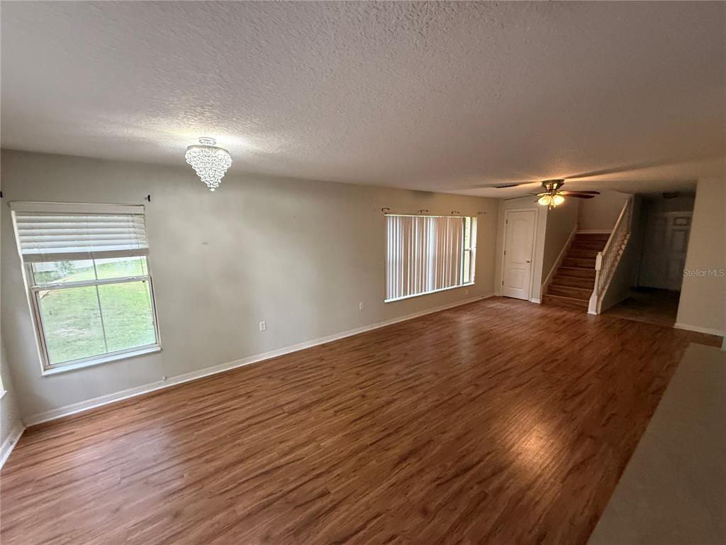 A living room with wood-look flooring, a crystal chandelier, and a staircase — 4521 LIMERICK DRIVE, TAMPA, FL