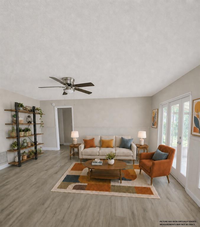 A room with wood-look flooring, a ceiling fan, white cabinets, and glass doors to a patio — 4518 GASPARILLA AVENUE, ORLANDO, FL