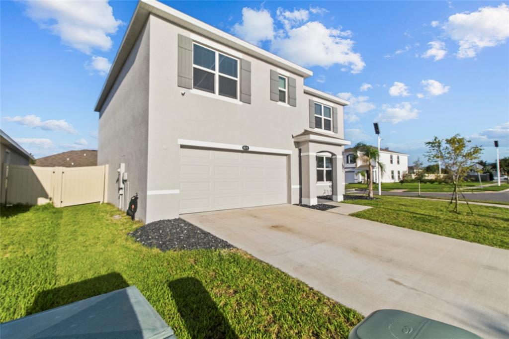 A two-story house with a light gray exterior, a two-car garage, and a concrete driveway — 8210 DOLPHIN BLUFF BOULEVARD, WESLEY CHAPEL, FL