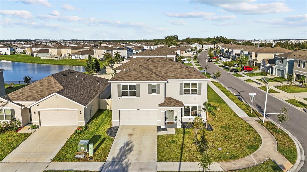 An aerial view of a two-story suburban house with a driveway and adjacent street — 8210 DOLPHIN BLUFF BOULEVARD, WESLEY CHAPEL, FL