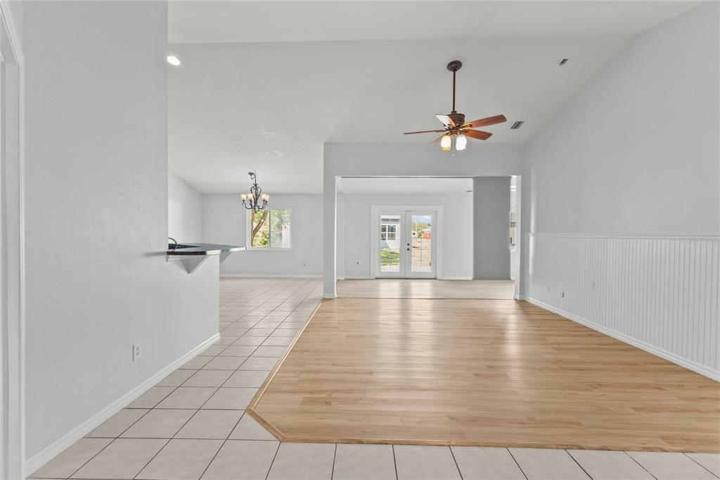 An open-concept living area features a mix of light-colored tile and wood-look flooring — 2373 AMNESTY DRIVE, NORTH PORT, FL