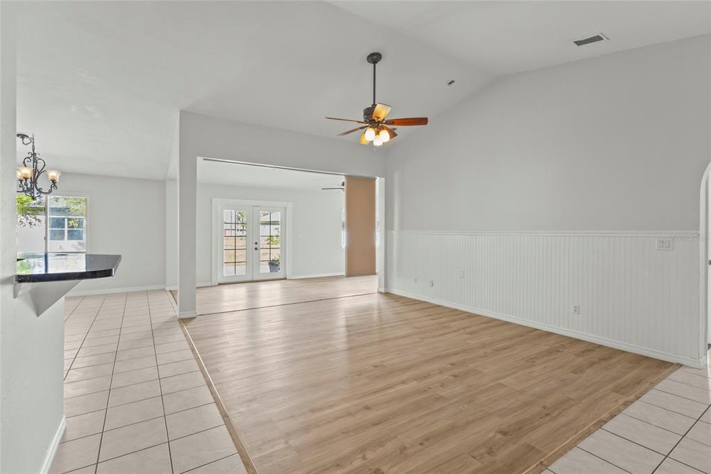 A living area with light wood flooring, white wainscoting, and a ceiling fan — 2373 AMNESTY DRIVE, NORTH PORT, FL
