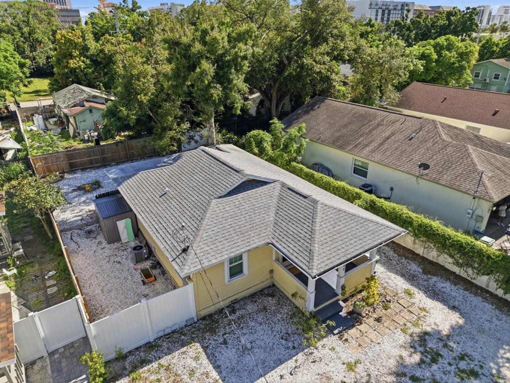 An empty room with hardwood floors, white trim, multiple windows, and a glass-paneled exterior door — 2048 5TH STREET, SARASOTA, FL
