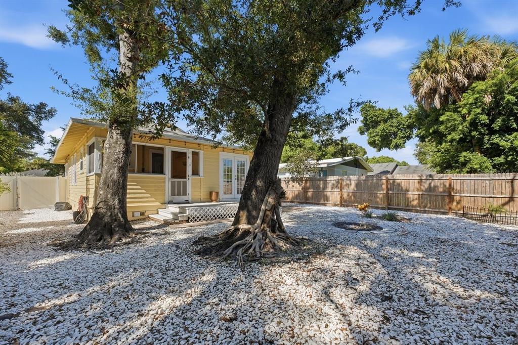 A yellow house exterior features a covered front porch with blue steps and white columns — 2048 5TH STREET, SARASOTA, FL