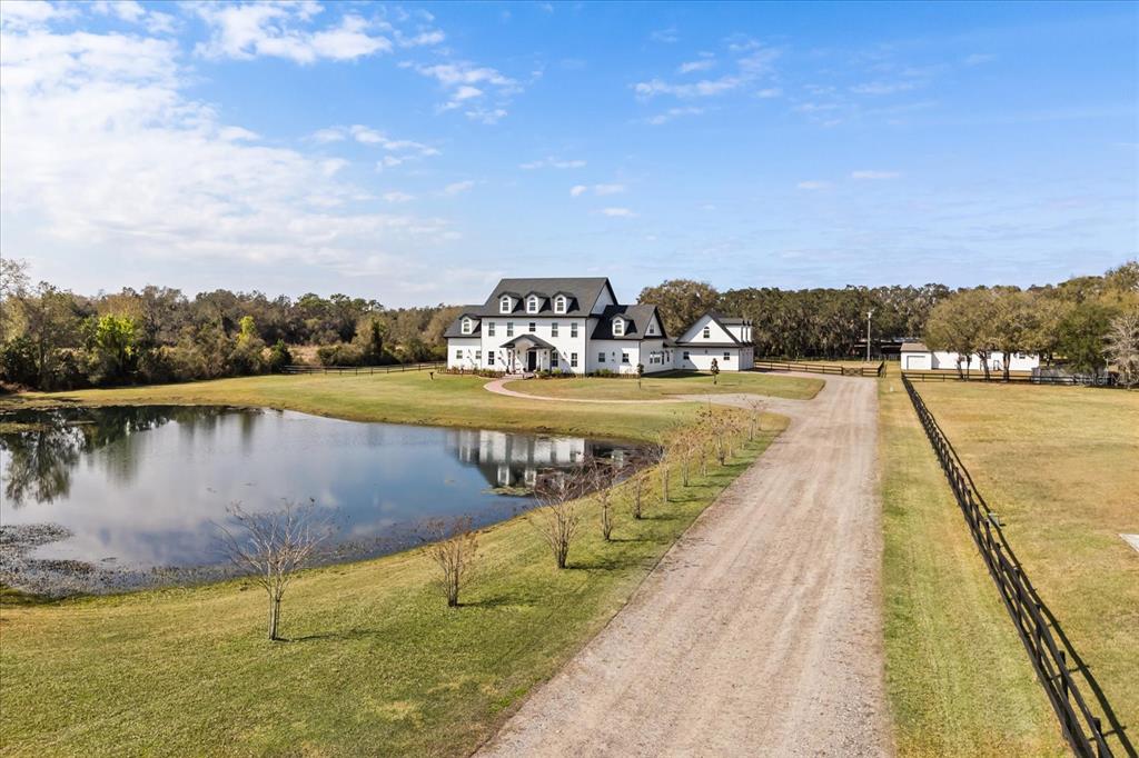 An aerial view of a white farmhouse with a pool, two gazebos, and surrounding pasture — 4510 PACKARD AVENUE, ST CLOUD, FL