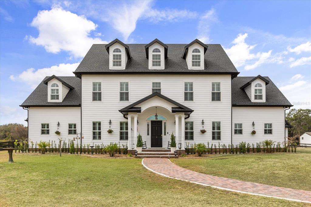 An aerial view shows a large white house with a pond and surrounding fields — 4510 PACKARD AVENUE, ST CLOUD, FL
