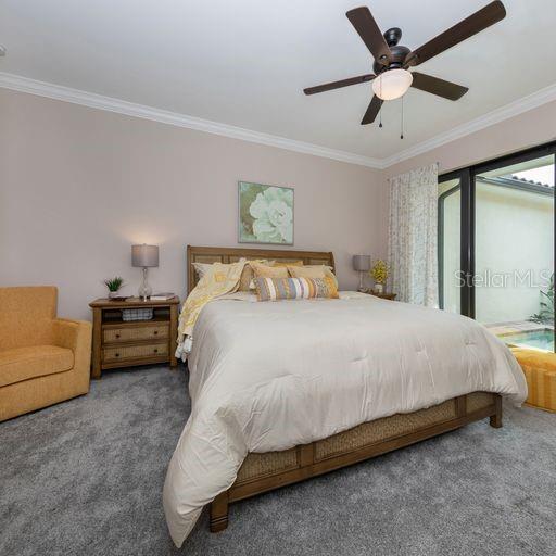A bedroom features a bed with a wooden frame, a ceiling fan, and sliding glass doors — 930 E VENICE AVENUE, VENICE, FL