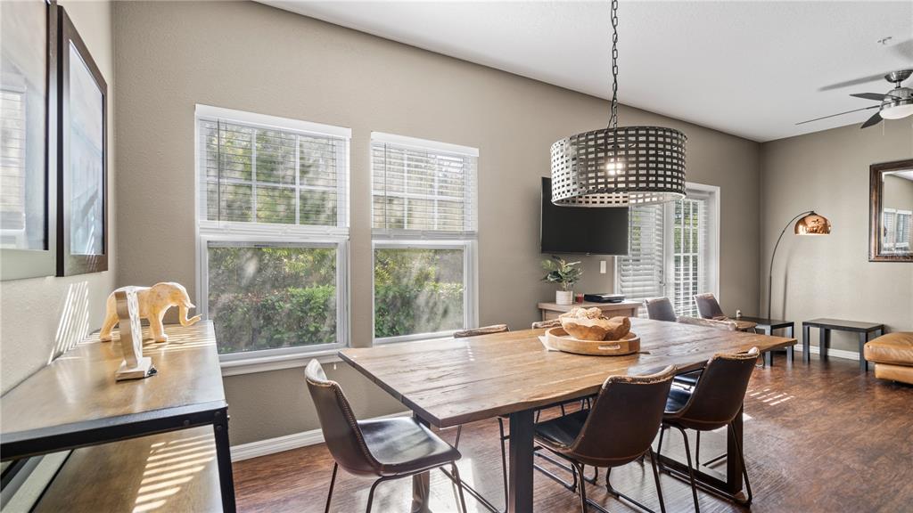 A dining room features a wooden table, dark chairs, a drum pendant light, and windows — 5350 DIPLOMAT COURT UNIT 104, KISSIMMEE, FL