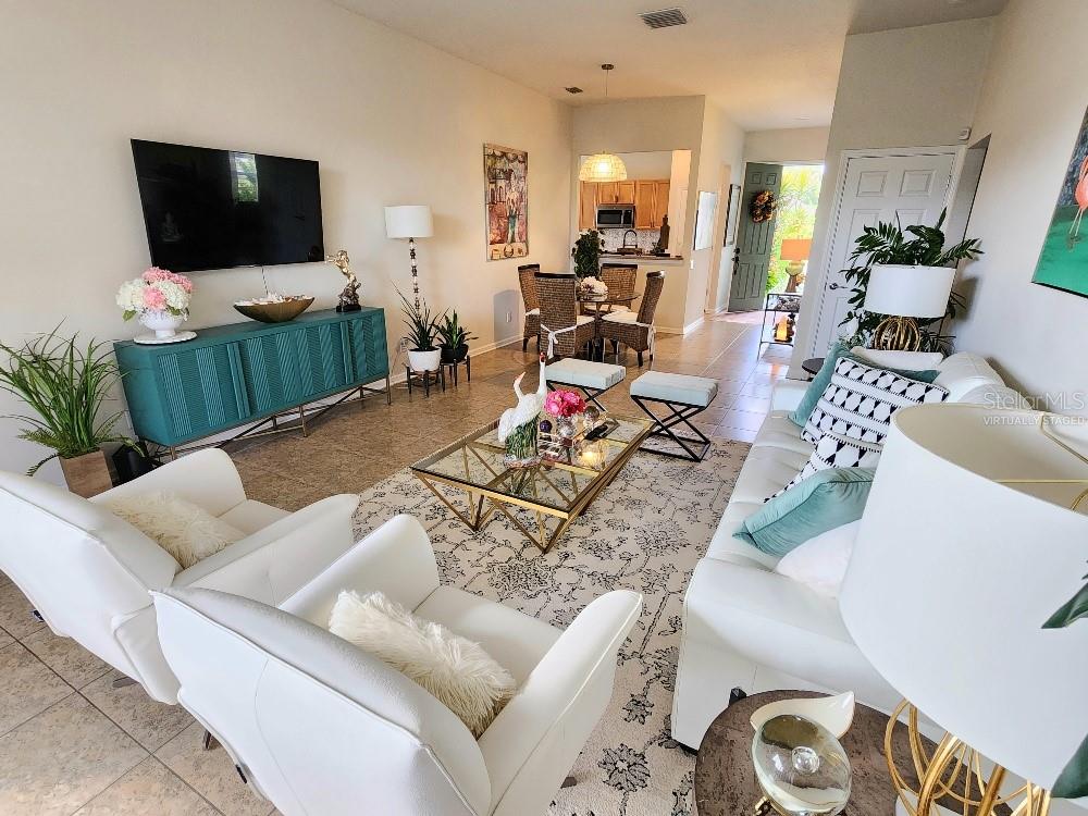 A living room features white furniture, a teal console, and a glass coffee table — 9820 50TH STREET CIRCLE E, PARRISH, FL