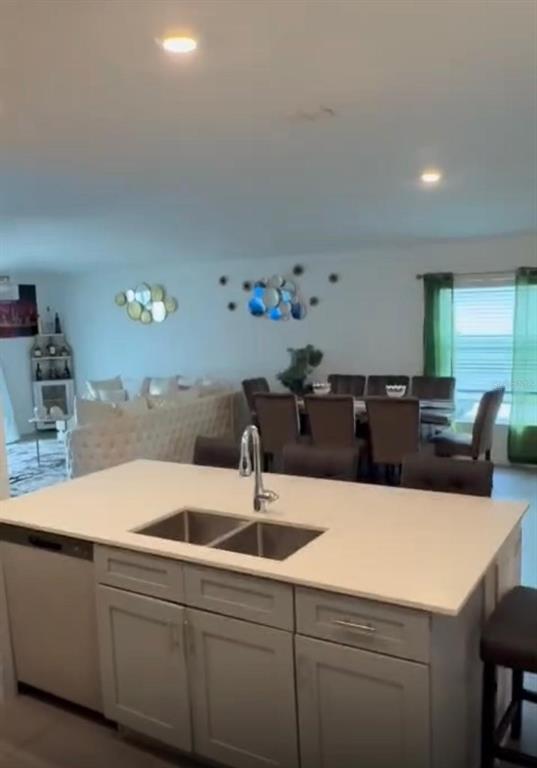 A kitchen island with a double sink faces a dining area and living room — 1946 POND PINE COURT, HAINES CITY, FL