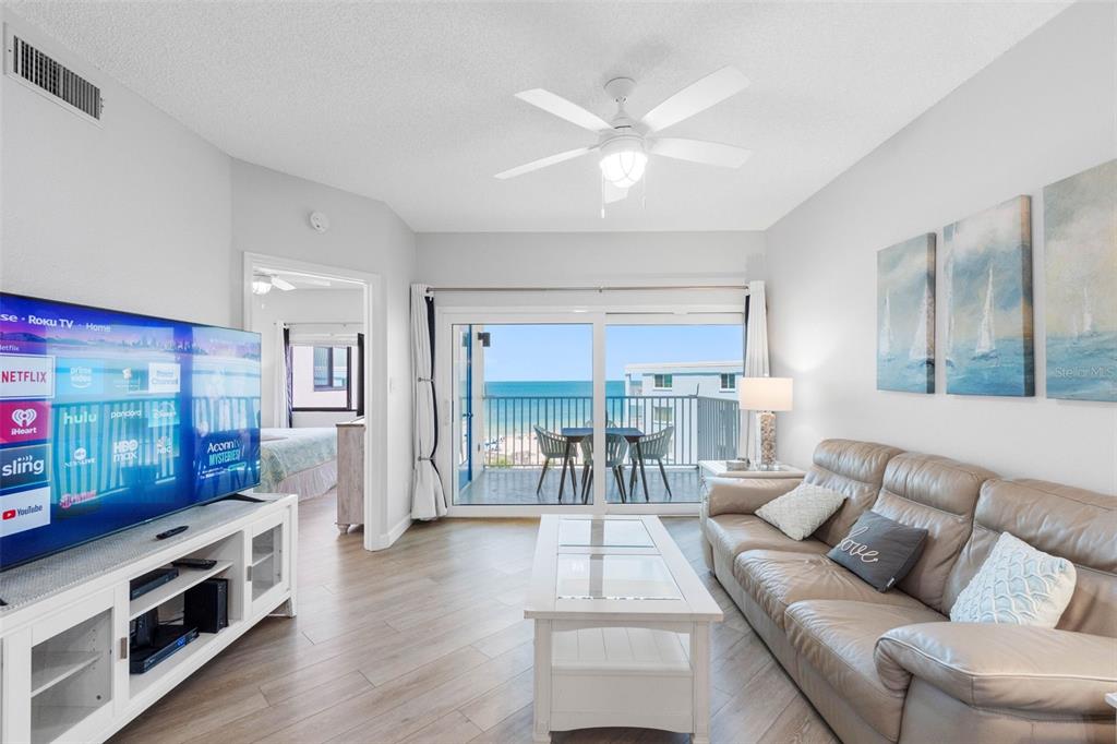 A living room with a leather sofa, white coffee table, and sliding doors overlooking the ocean — 18450 GULF BOULEVARD UNIT 508, INDIAN SHORES, FL