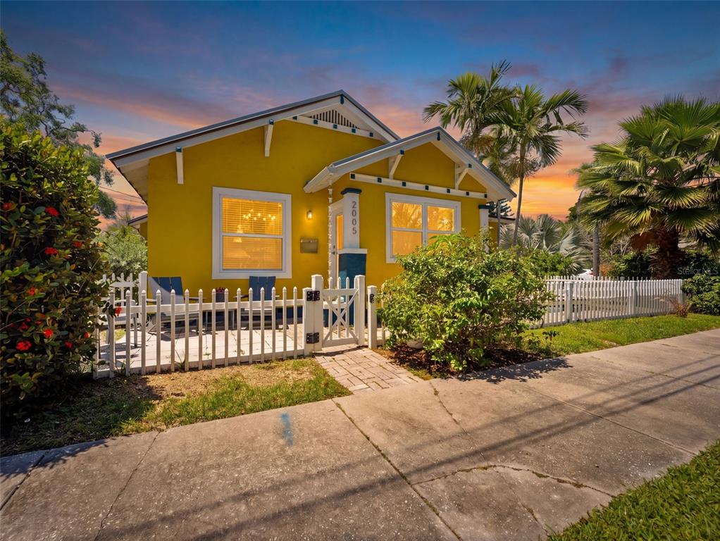 A bright yellow bungalow with a metal roof and a small front patio with chairs — 2005 3RD STREET S, ST PETERSBURG, FL