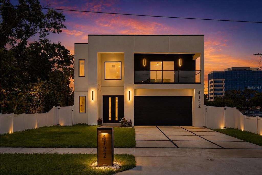 A modern two-story house with a black garage door and a lit mailbox at dusk — 4122 W NASSAU STREET, TAMPA, FL