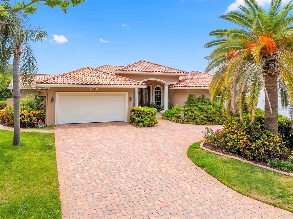 A single-story house with a tiled roof, a paved driveway, and a large palm tree — 2001 ILLINOIS AVE NE, ST PETERSBURG, FL