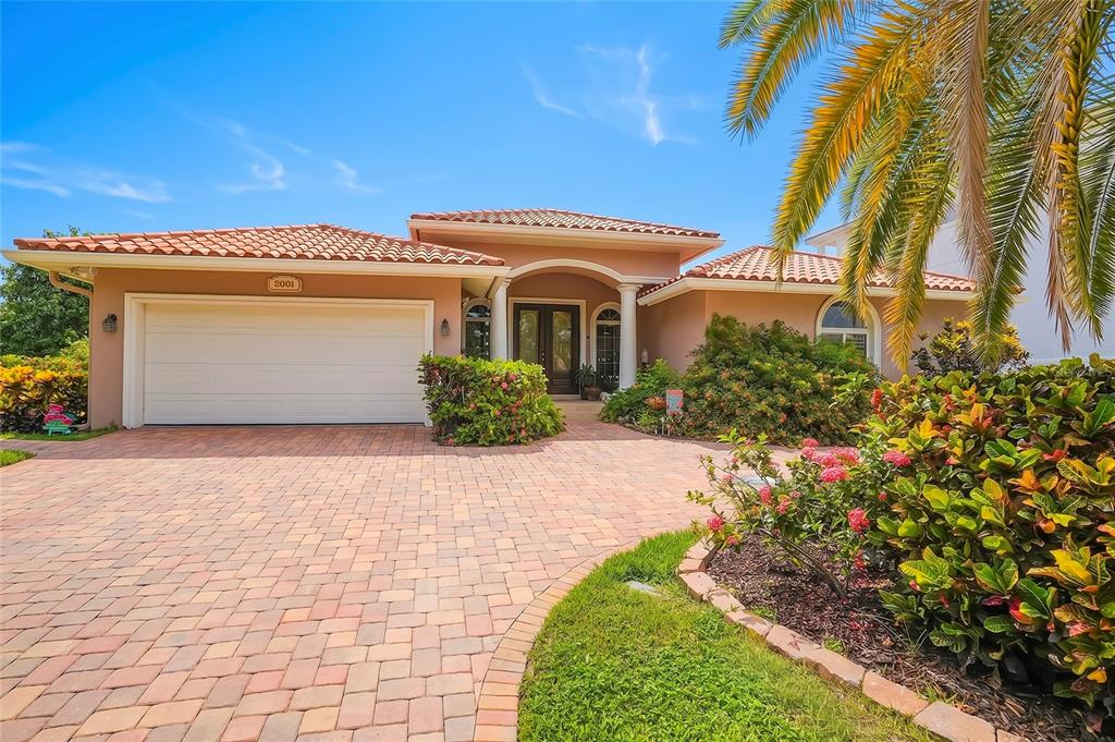 A paved walkway leads to the front entrance of a house with two white columns — 2001 ILLINOIS AVE NE, ST PETERSBURG, FL
