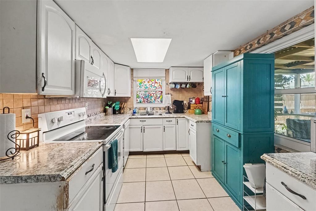A single-story house with a gray exterior, a front-facing garage, and a large grassy yard — 8143 HIXTON DRIVE, PORT RICHEY, FL