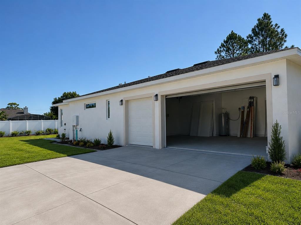 A white exterior wall features a single-car garage door and an open two-car garage bay — 18891 NETHERLAND STREET, ORLANDO, FL