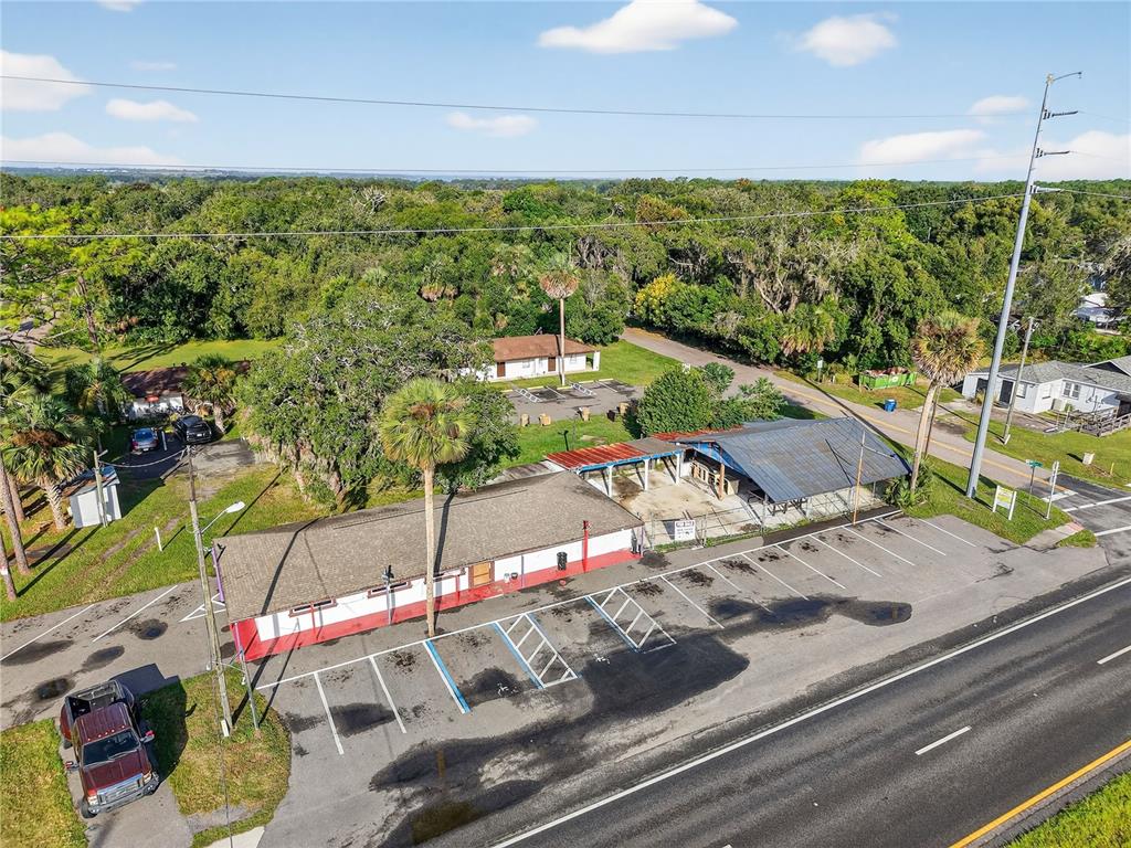 An aerial view shows a commercial building with a parking lot next to a road — 37415 STATE ROAD 19, UMATILLA, FL