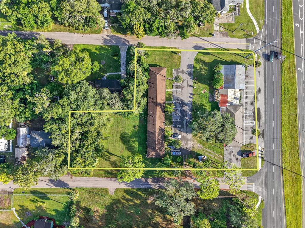 An aerial view shows a commercial property with a long building, parking lot, and trees — 37415 STATE ROAD 19, UMATILLA, FL
