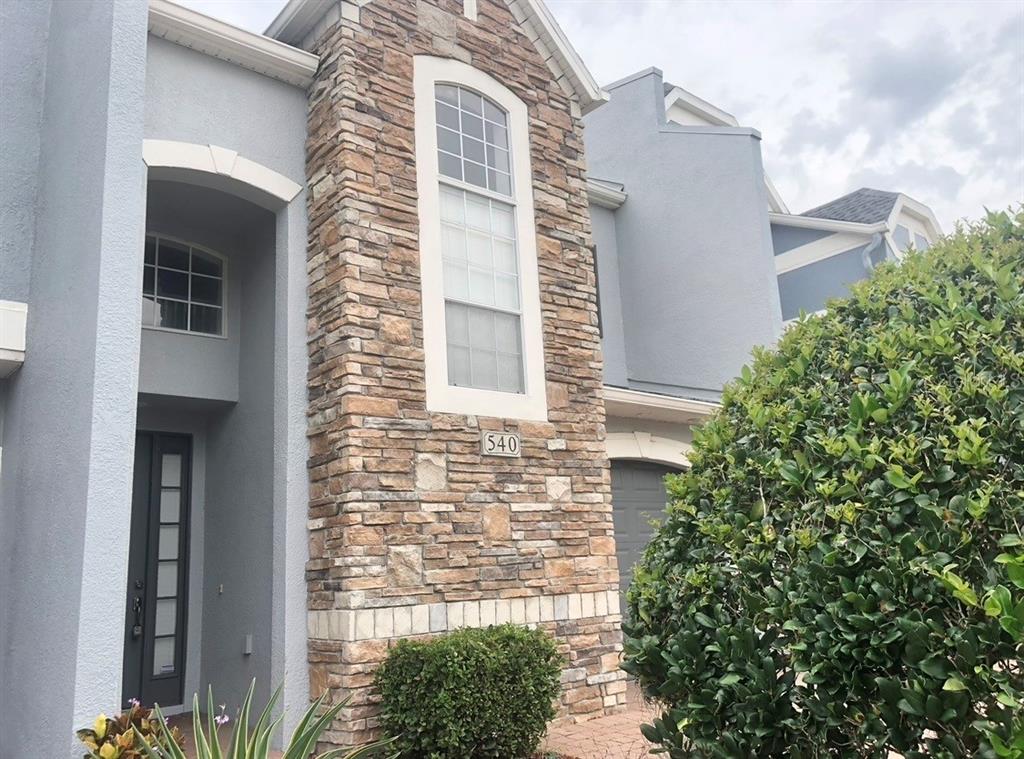 The exterior of a two-story house features gray stucco walls and a stone veneer facade — 540 WOODLAND TERRACE BOULEVARD, ORLANDO, FL