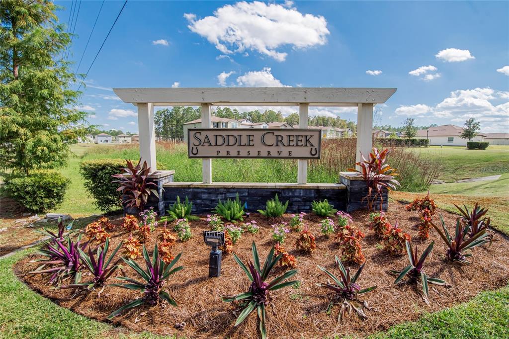 A single-story house with a gray stucco exterior, a two-car garage, and dark window shutters — 1748 RED LOOP, LAKELAND, FL