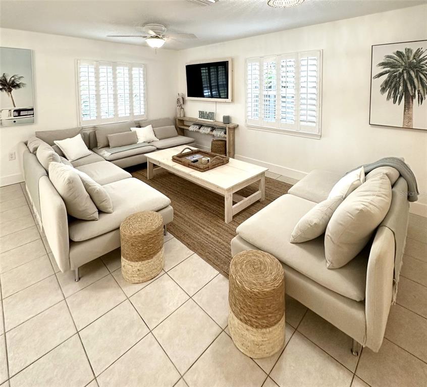 A living room features light-colored sofas, a wooden coffee table, and tile flooring — 839 FLORIDA AVENUE, PALM HARBOR, FL