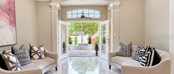 A bright foyer features a crystal chandelier, large floor mirror, and light-colored tile flooring — 10133 FACET COURT, ORLANDO, FL