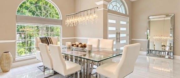 A living room with two curved sofas, tile flooring, and glass doors leading to a patio — 10133 FACET COURT, ORLANDO, FL