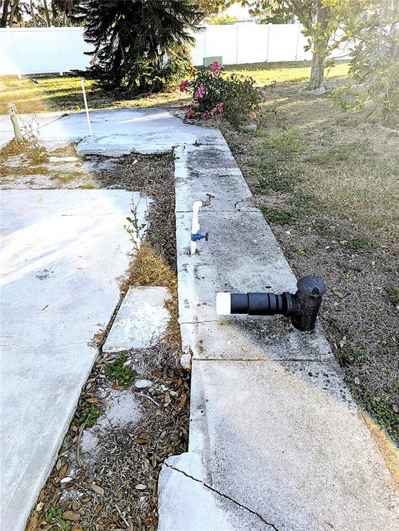An outdoor concrete slab features a water spigot and a black plumbing fixture — 3275 26TH AVENUE E UNIT 55, BRADENTON, FL