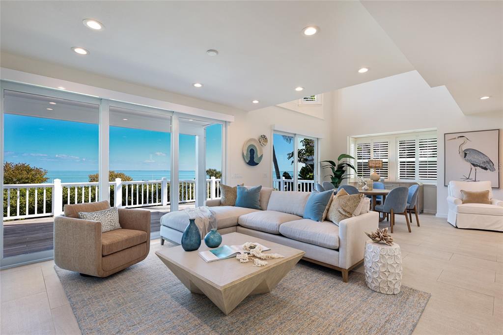 A bright living room features a sectional sofa, a coffee table, and large sliding glass doors — 585 BUTTONWOOD BAY DRIVE, BOCA GRANDE, FL