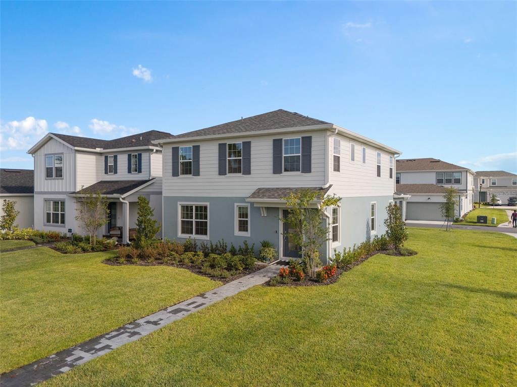 A two-story house with light blue and white siding features a front walkway and landscaping — 10876 WATERWOOD ALLEY, ORLANDO, FL