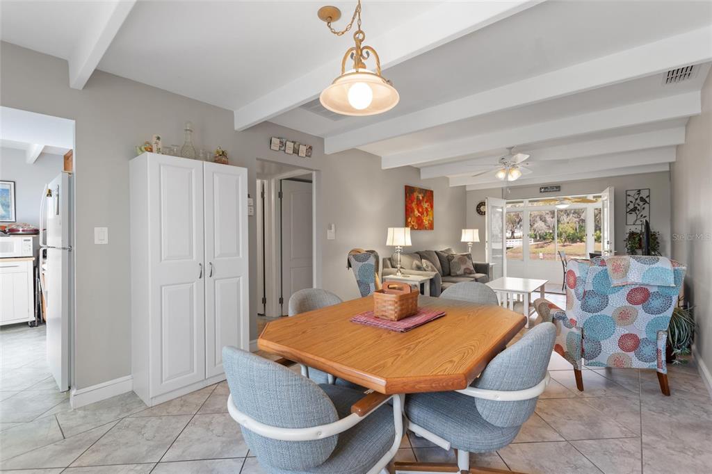 A dining area with a wooden table and chairs opens into a living room — 1919 CLUB CIRCLE, LAKESHORE, FL