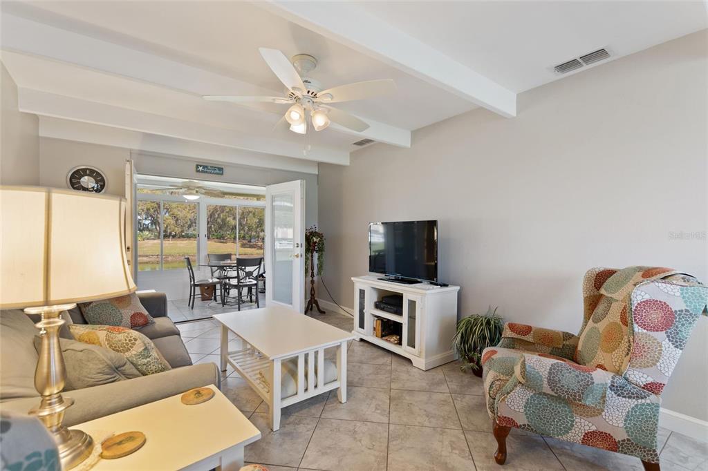 A living room with tile floors, a ceiling fan, and a view of a patio — 1919 CLUB CIRCLE, LAKESHORE, FL