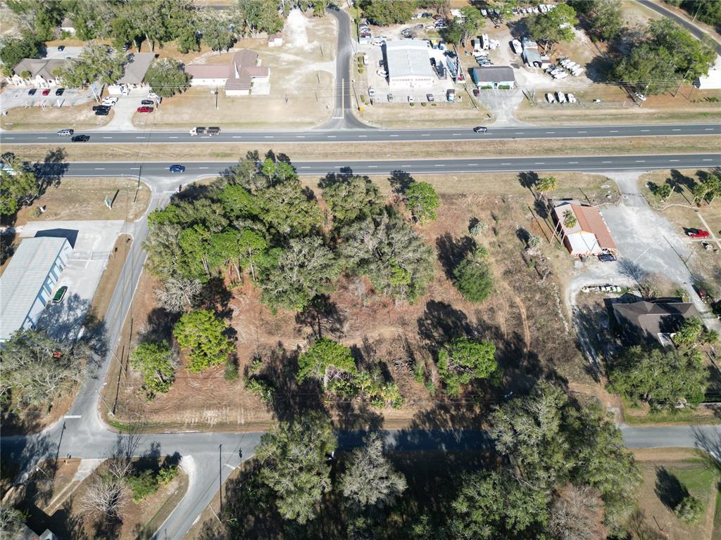 An aerial view shows a vacant, wooded lot situated between a highway and a side road — 7280 SE 123RD LANE, BELLEVIEW, FL