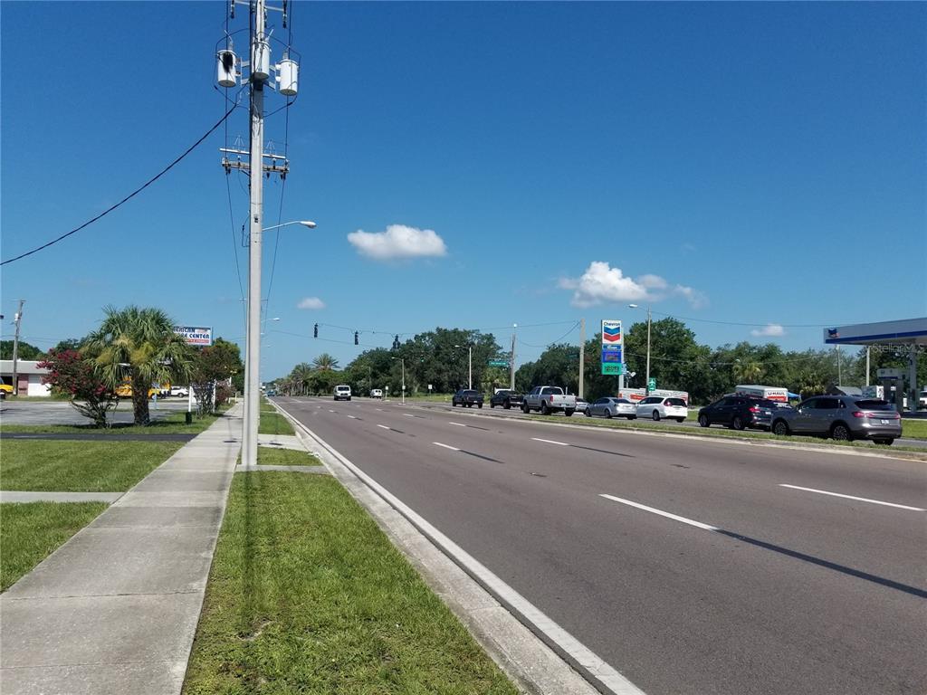 A paved road stretches into the distance past a utility pole and a gas station — 2050 HAVENDALE BOULEVARD NW UNIT B, WINTER HAVEN, FL