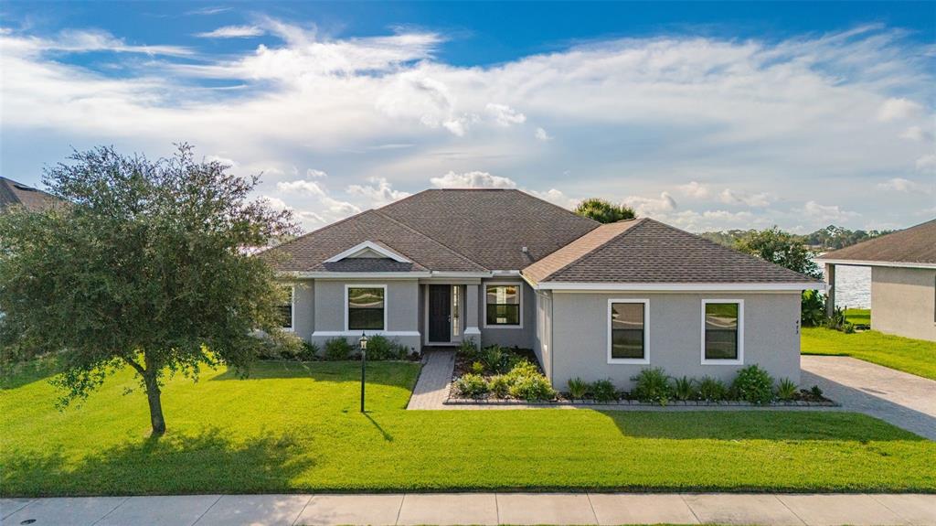 A single-story gray house with a shingled roof, a front lawn, and a paved walkway — 473 LAKE VIEW WAY, AUBURNDALE, FL