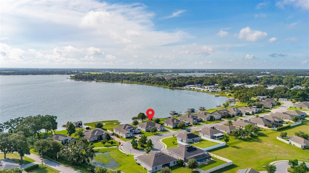 An aerial view shows a suburban neighborhood of single-family homes situated along a large lake — 473 LAKE VIEW WAY, AUBURNDALE, FL