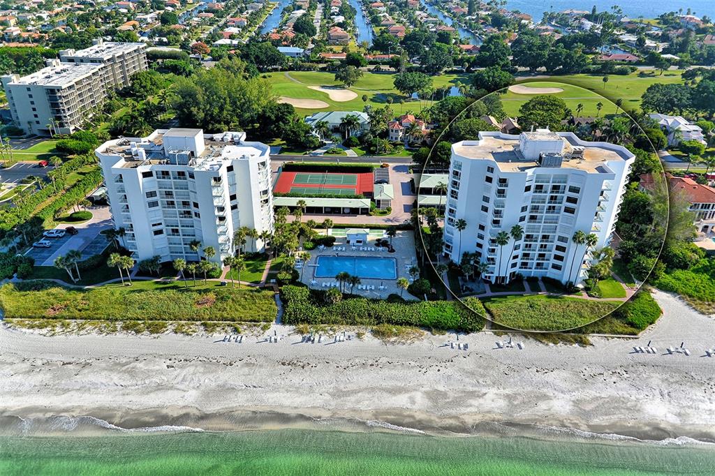 An aerial view of two beachfront condominium towers with a swimming pool and tennis courts — 1000 LONGBOAT CLUB ROAD UNIT 403, LONGBOAT KEY, FL