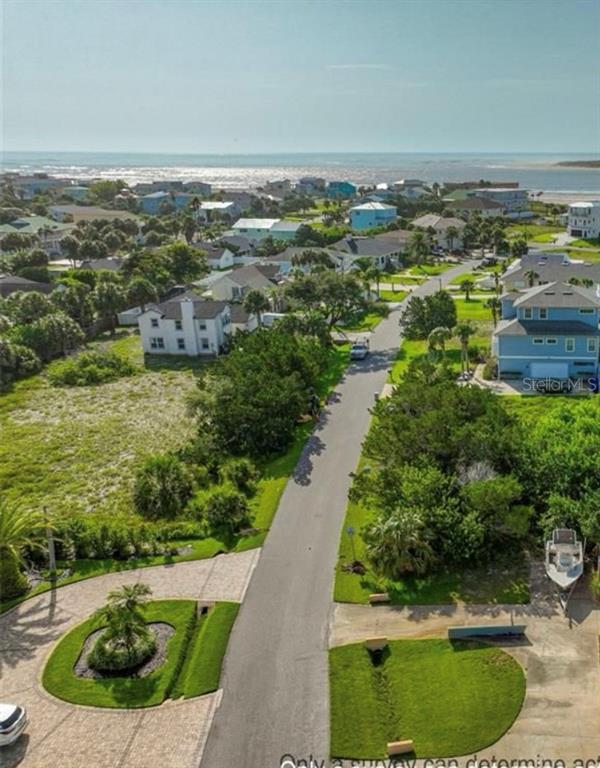 An aerial view shows a residential street leading toward the ocean with surrounding coastal homes — 204 SEA TURTLE WAY, ST AUGUSTINE, FL