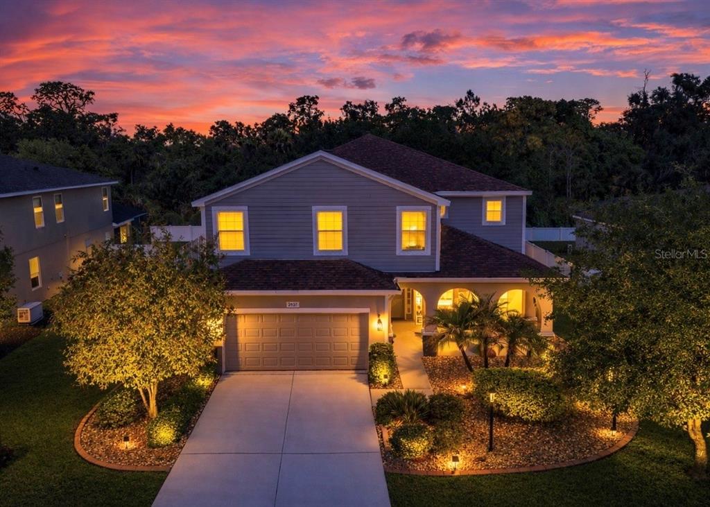 An aerial view of a two-story suburban house with a garage at sunset — 2927 130TH AVENUE E, PARRISH, FL