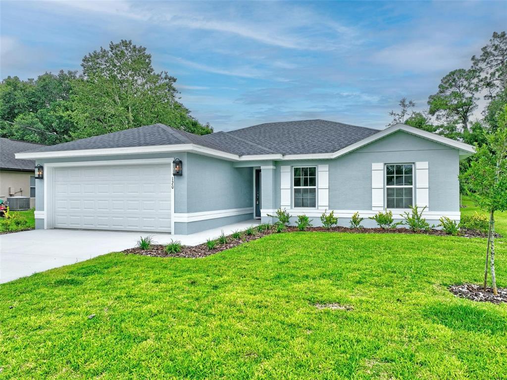 A light blue single-story house with a two-car garage and a landscaped front yard — 107 PEPPERDINE DRIVE, PALM COAST, FL