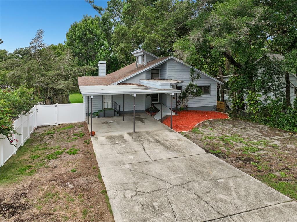 A light blue house with a carport, a concrete driveway, and a white fence — 210 EDGEWOOD AVENUE, CLEARWATER, FL