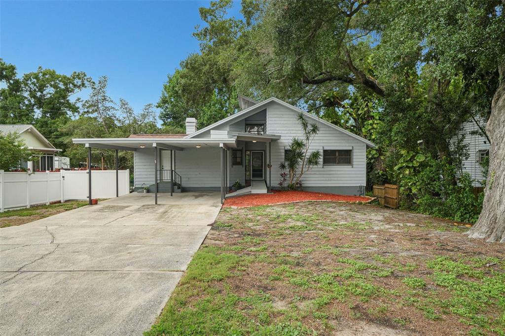 A light gray house with a carport and a front yard with red mulch — 210 EDGEWOOD AVENUE, CLEARWATER, FL
