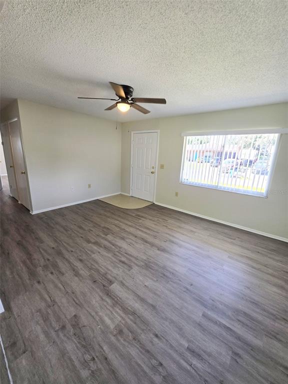 A living room with light-colored walls, wood-look flooring, a ceiling fan, and a front door — 310 VANIMAN AVENUE, WINTER HAVEN, FL