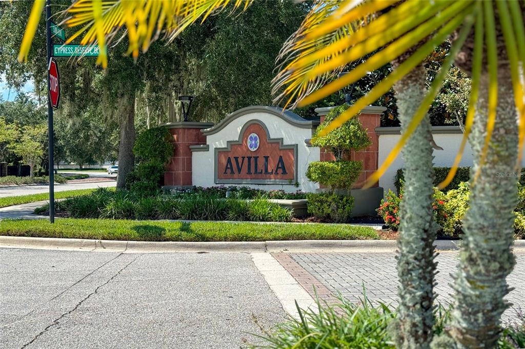 A stone monument sign for the Avilla community stands near a street intersection — 2770 SWOOP CIRCLE, KISSIMMEE, FL