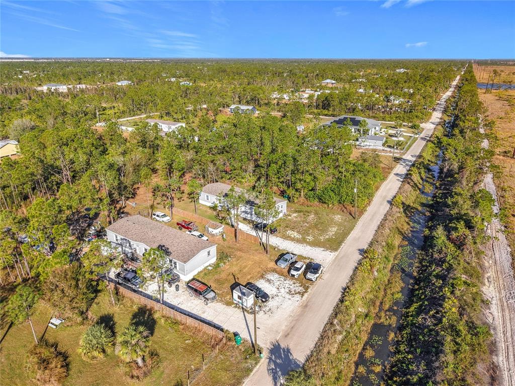 An aerial view shows a residential property with two mobile homes and several parked vehicles — 8325 STRASSE BOULEVARD, PUNTA GORDA, FL